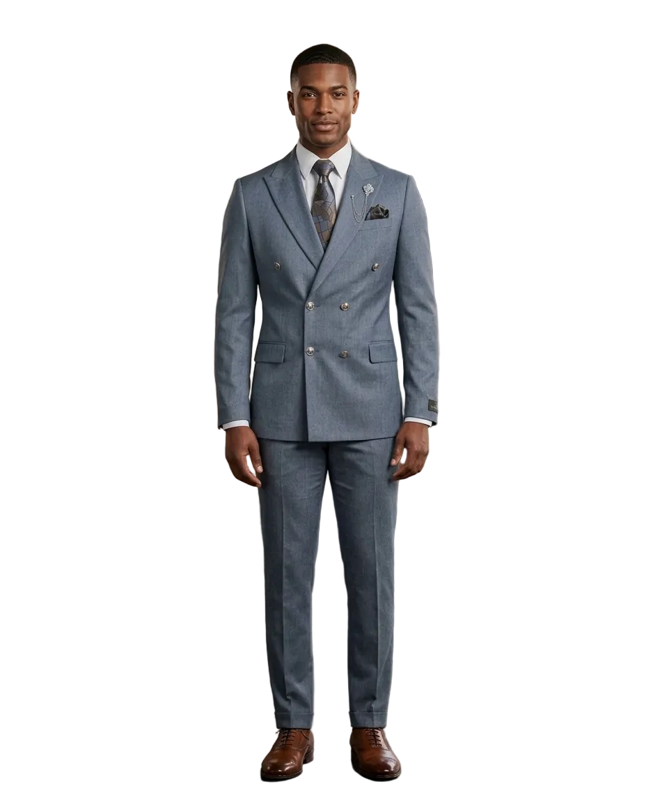 A man wearing a light blue double-breasted suit with a white shirt, patterned tie, and brown dress shoes, standing in a modern loft-style room with wood paneling, brick walls, and large windows.