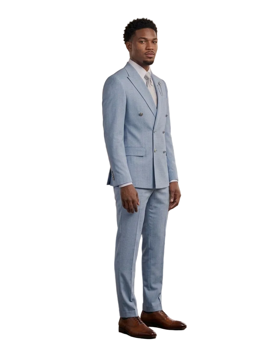 A man wearing a light blue double-breasted suit, white dress shirt, and light tie, standing in a modern loft-style room with wood paneling, brick walls, and large windows.