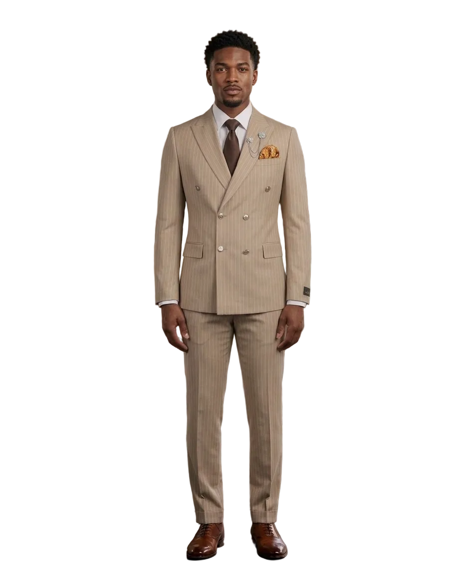 A man wearing a beige double-breasted pinstripe suit with a white shirt, brown tie, and orange pocket square, standing in a modern loft office setting.